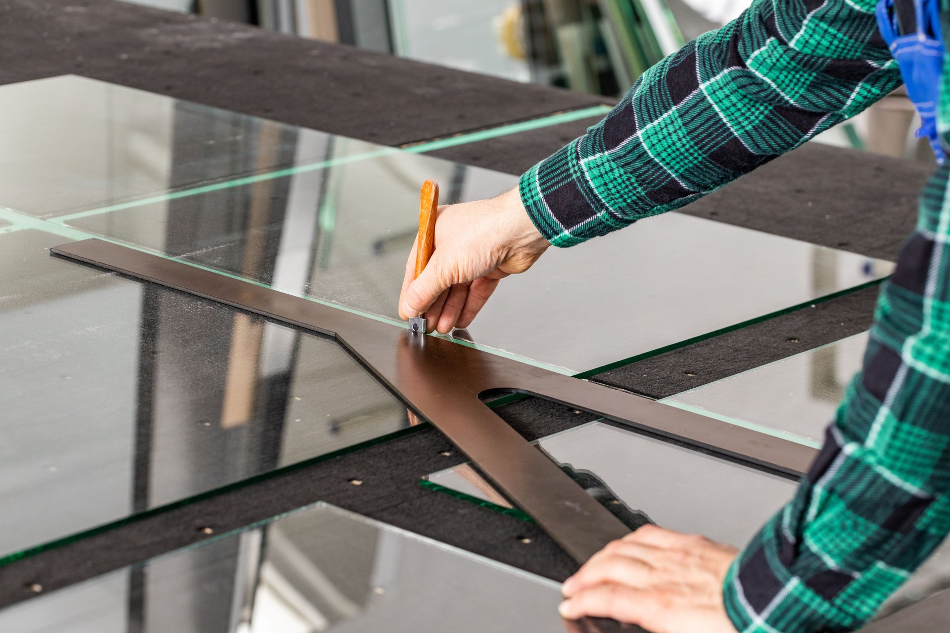 The glazier cuts the glass in the glass factory, the cutter and the glass angle